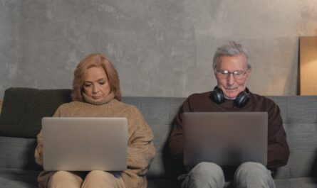 Woman in Brown Sweater Sitting on Brown Sofa Beside Man in Black Sunglasses