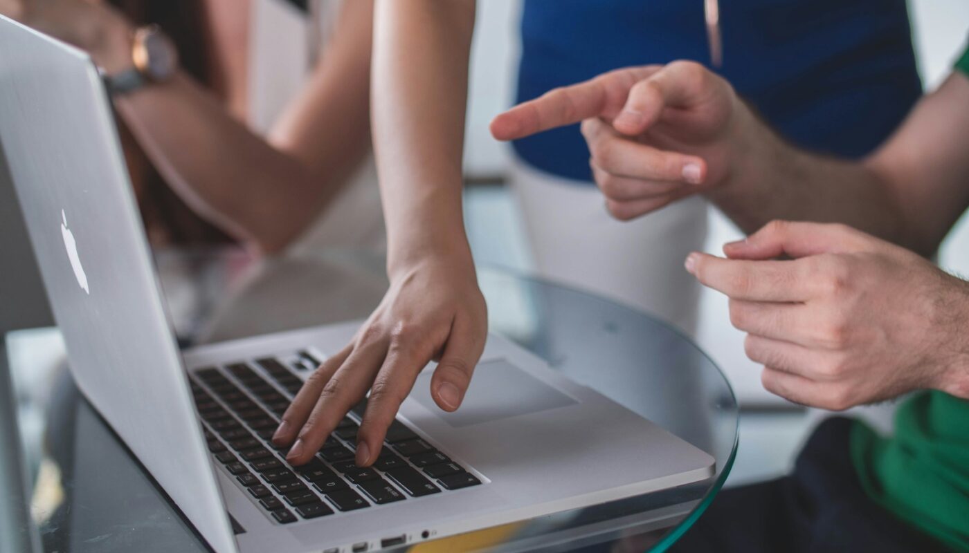 person touching and pointing MacBook Pro